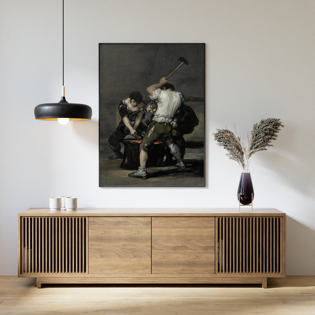 Framed art print of The Forge by Francisco de Goya, above a slatted wood sideboard