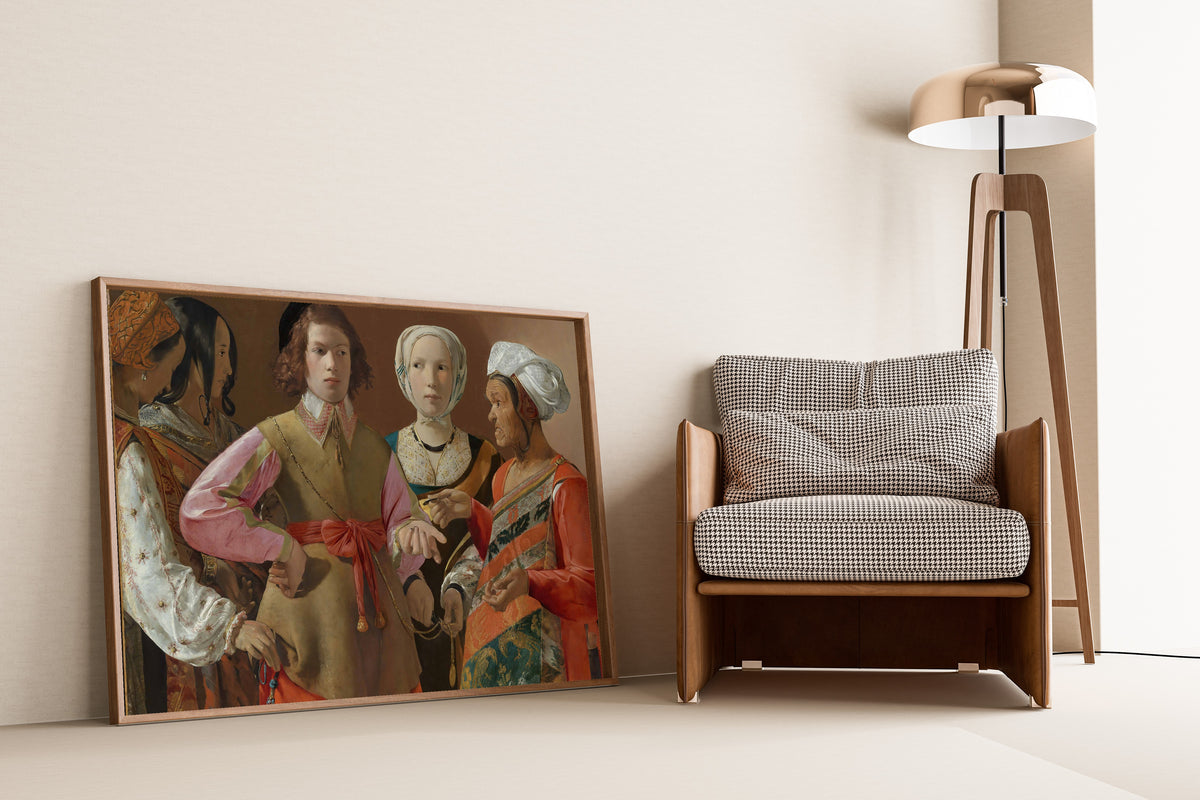 Framed art print of The Fortune-Teller by Georges de La Tour, leaning against a wall beside an armchair and a floor lamp