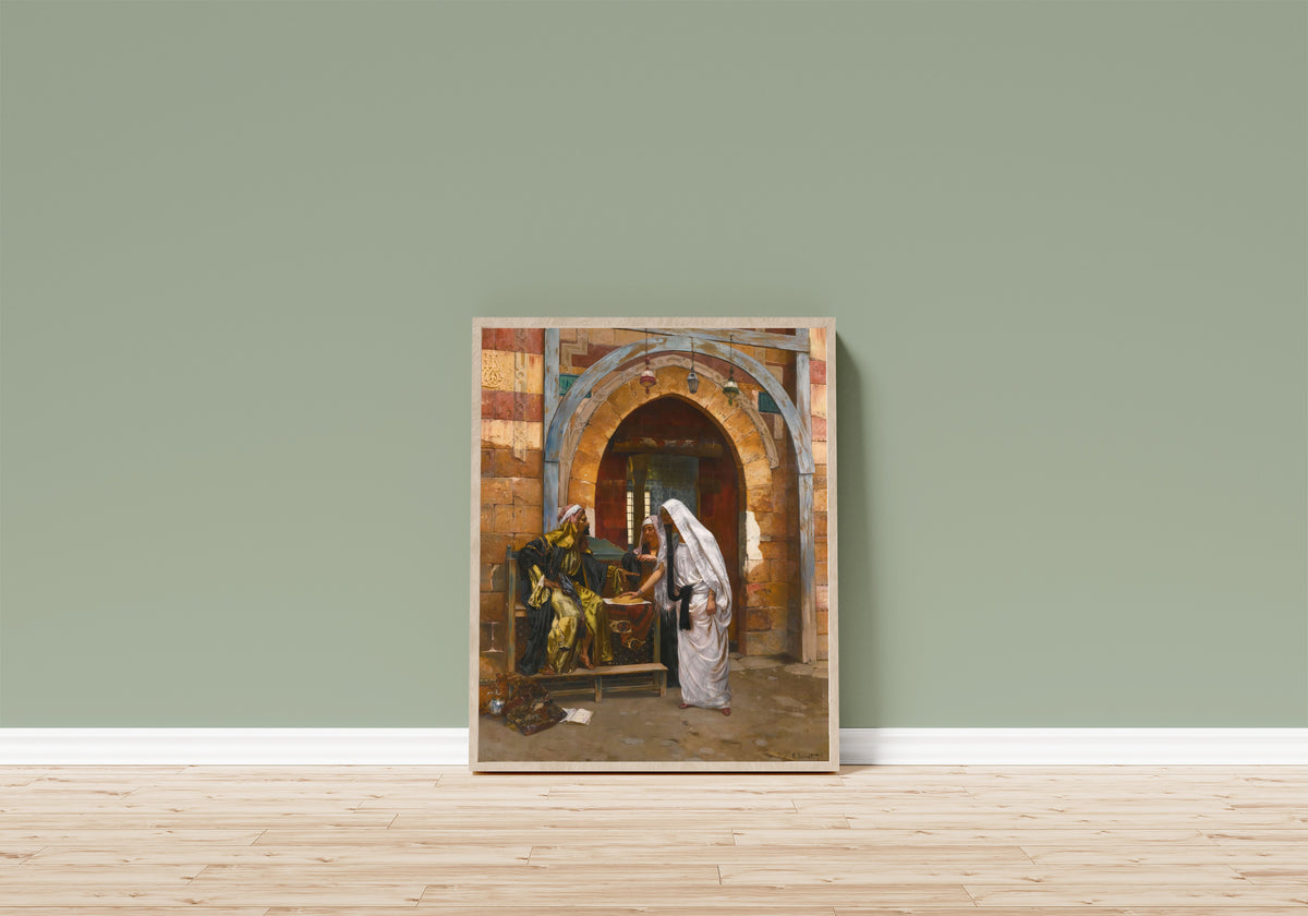 Framed art print of The Fortune Teller by Rudolf Ernst, in a light wood frame leaning on a sage green wall above a wooden floor