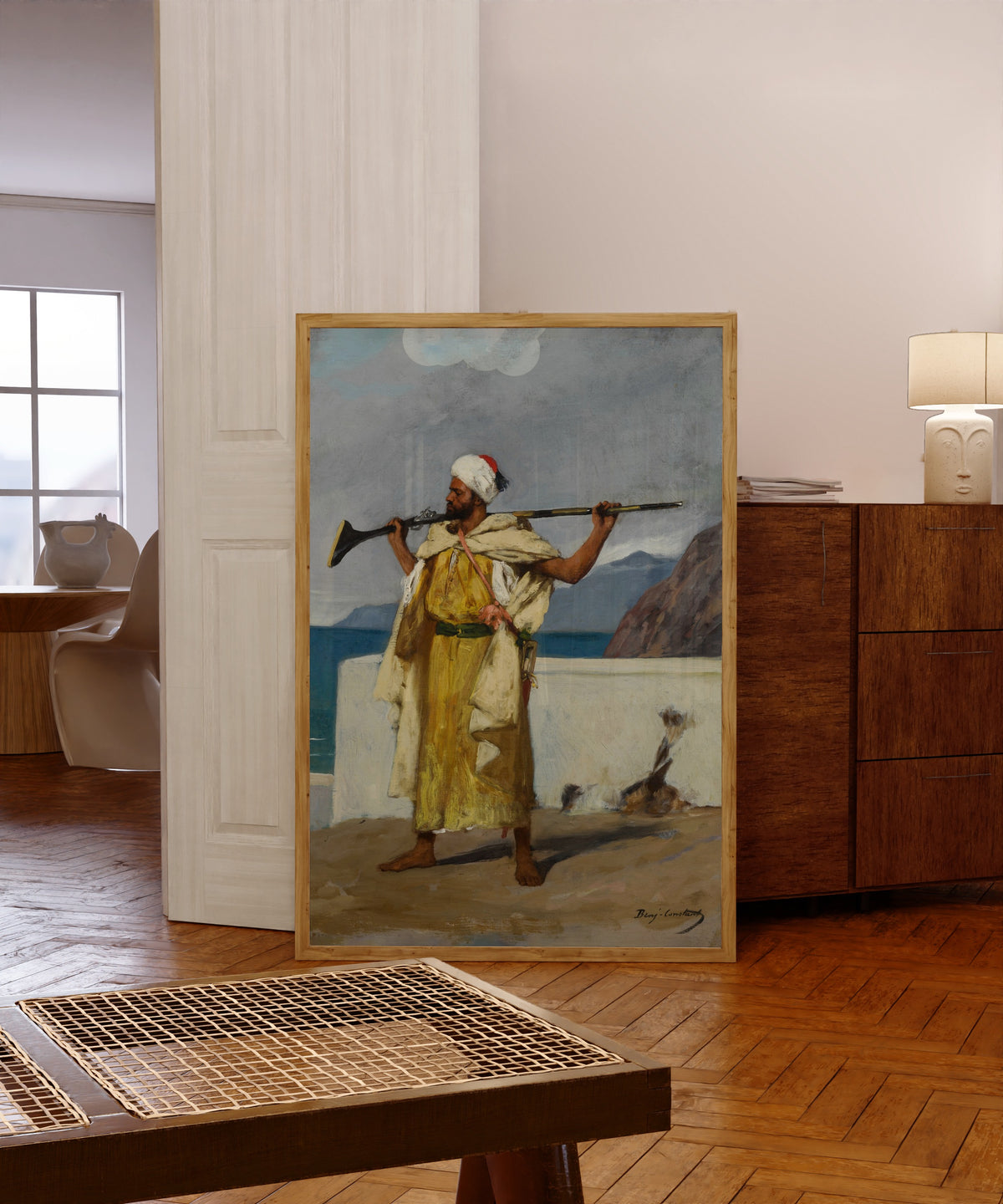 Framed art print of The Guard by Jean-Joseph Benjamin-Constant, in a light wood frame leaning in a warm room with a parquet floor