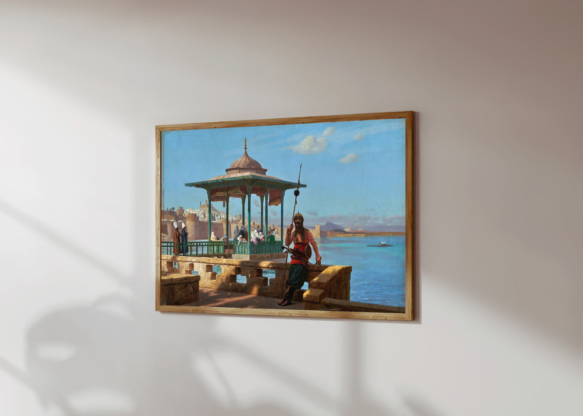 Framed art print of The Harem in the Kiosk by Jean-Léon Gérôme, in a light wood frame on a sunlit white wall, seen at a slight angle