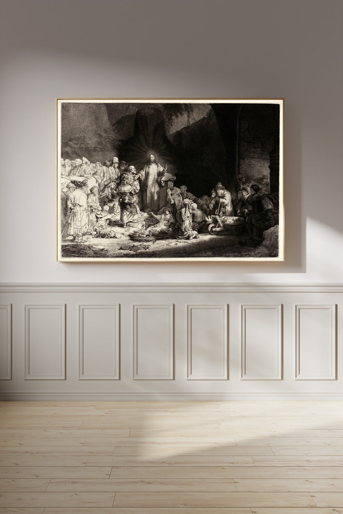 Framed art print of The Hundred Guilder Print by Rembrandt van Rijn, on a panelled wall in afternoon light