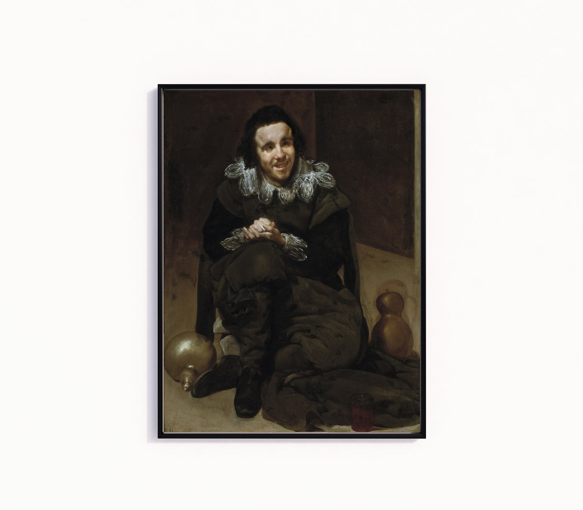 Framed art print of The Jester Calabacillas by Diego Velázquez, in a slim black frame on a plain white wall