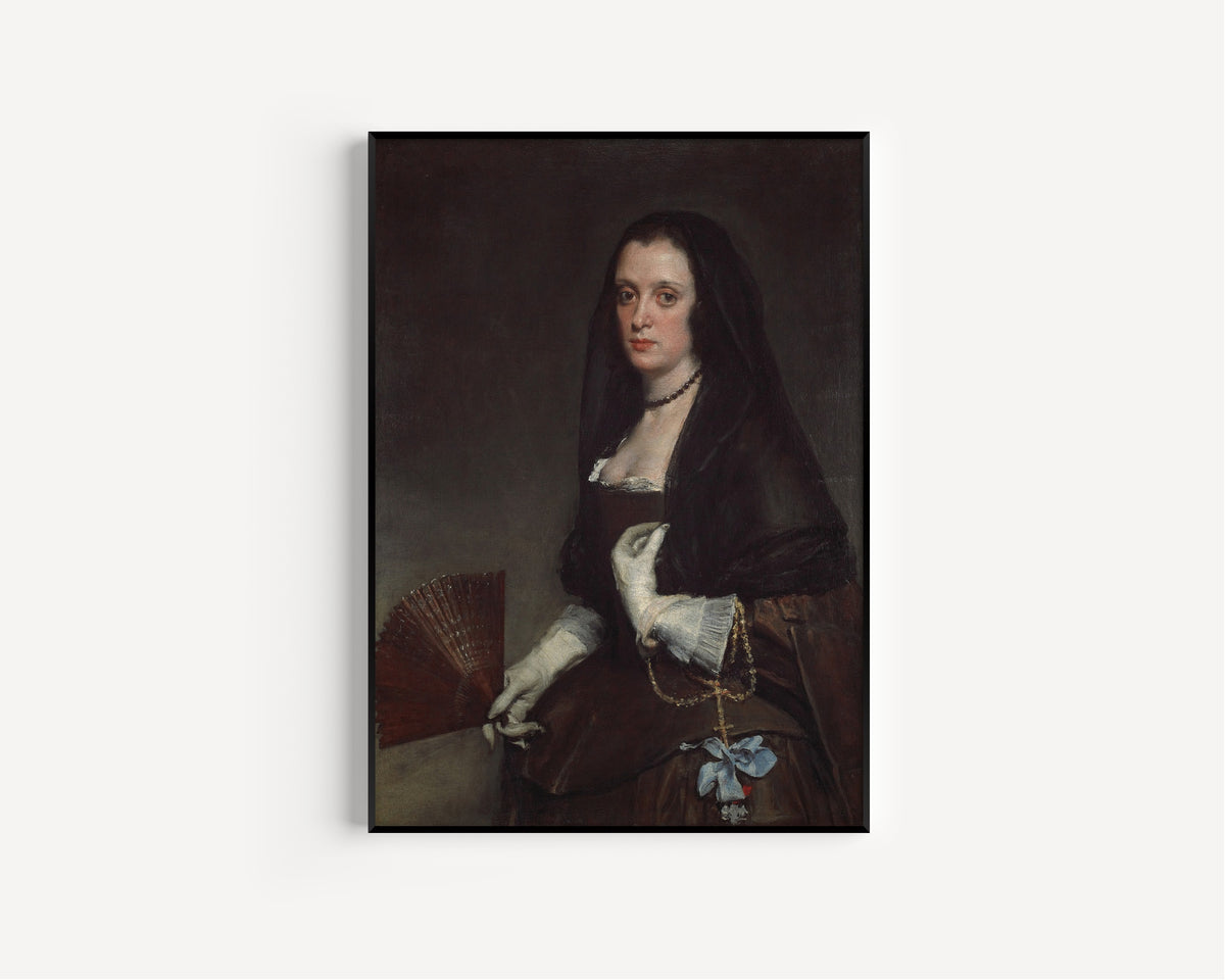 Framed art print of The Lady with a Fan by Diego Velázquez, in a slim black frame on a plain white wall