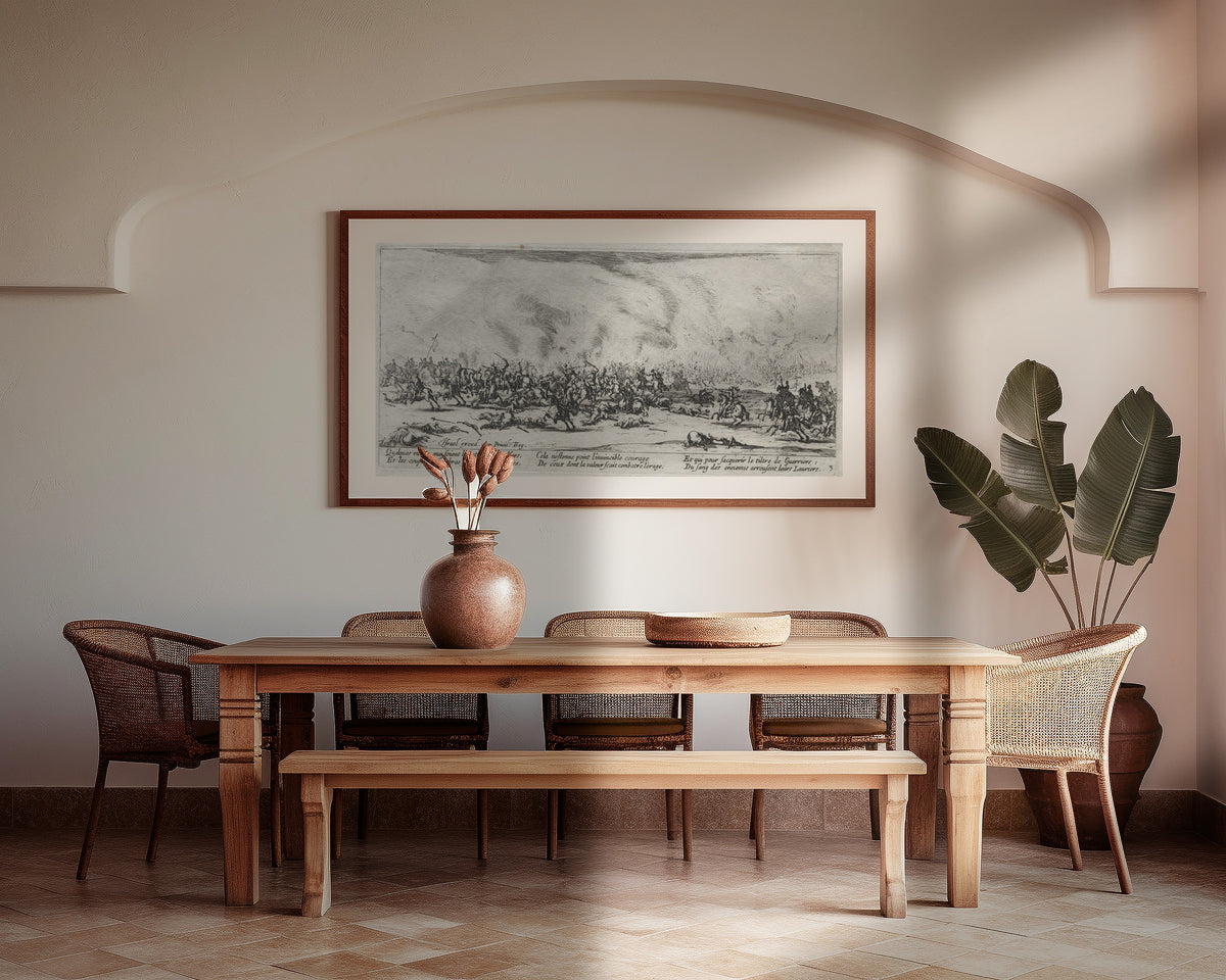 Framed art print of The Large Miseries of War: The Battle by Jacques Callot, above a wooden dining table