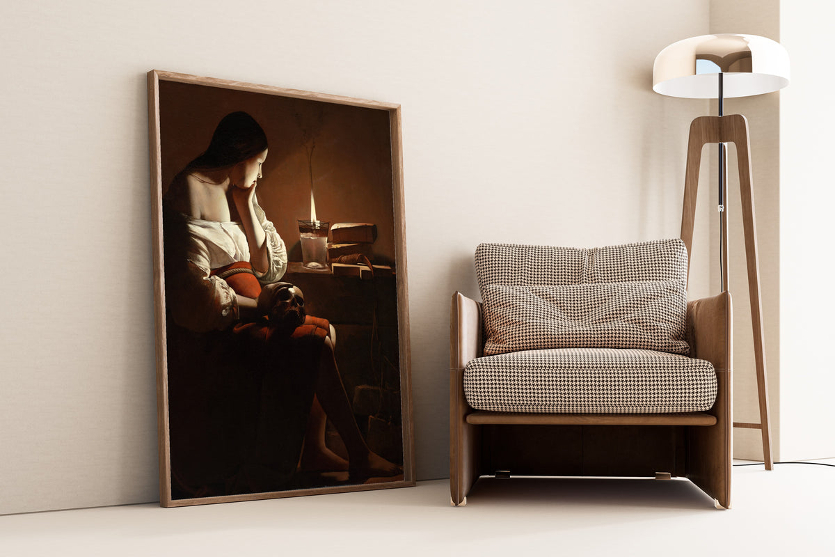 Framed art print of The Magdalen with the Smoking Flame by Georges de La Tour, leaning against a wall beside an armchair and a floor lamp