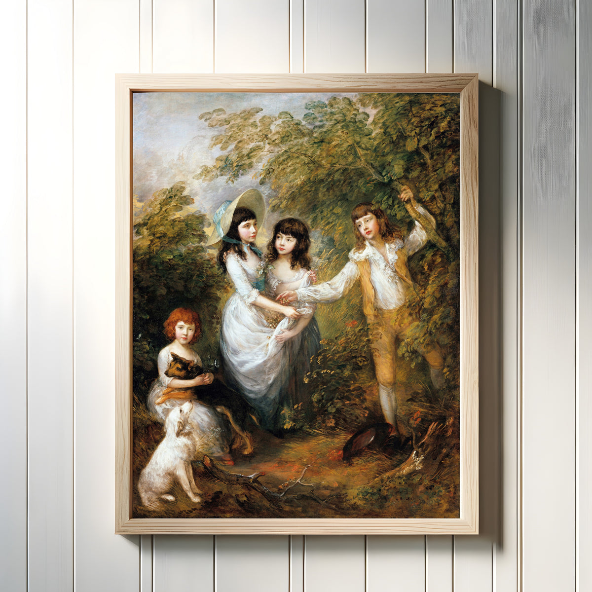Framed art print of The Marsham Children by Thomas Gainsborough, in a light wood frame on a white panelled wall