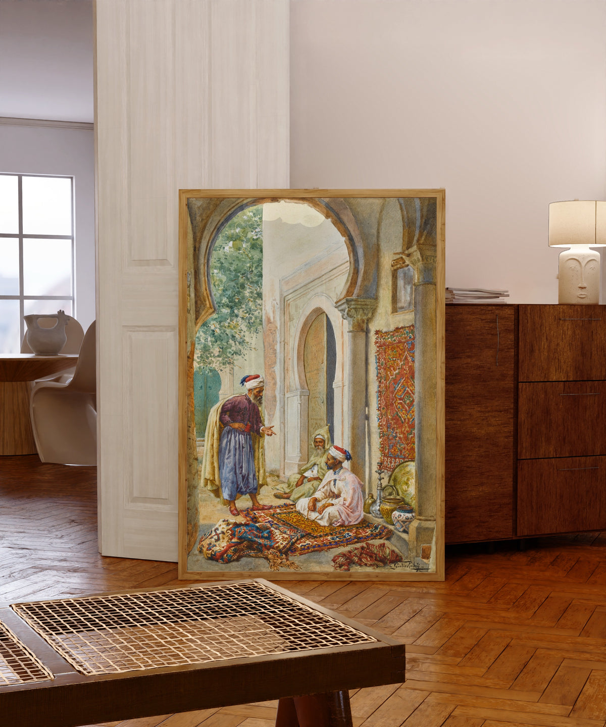 Framed art print of The Merchant by Giulio Rosati, in a light wood frame leaning in a warm room with a parquet floor