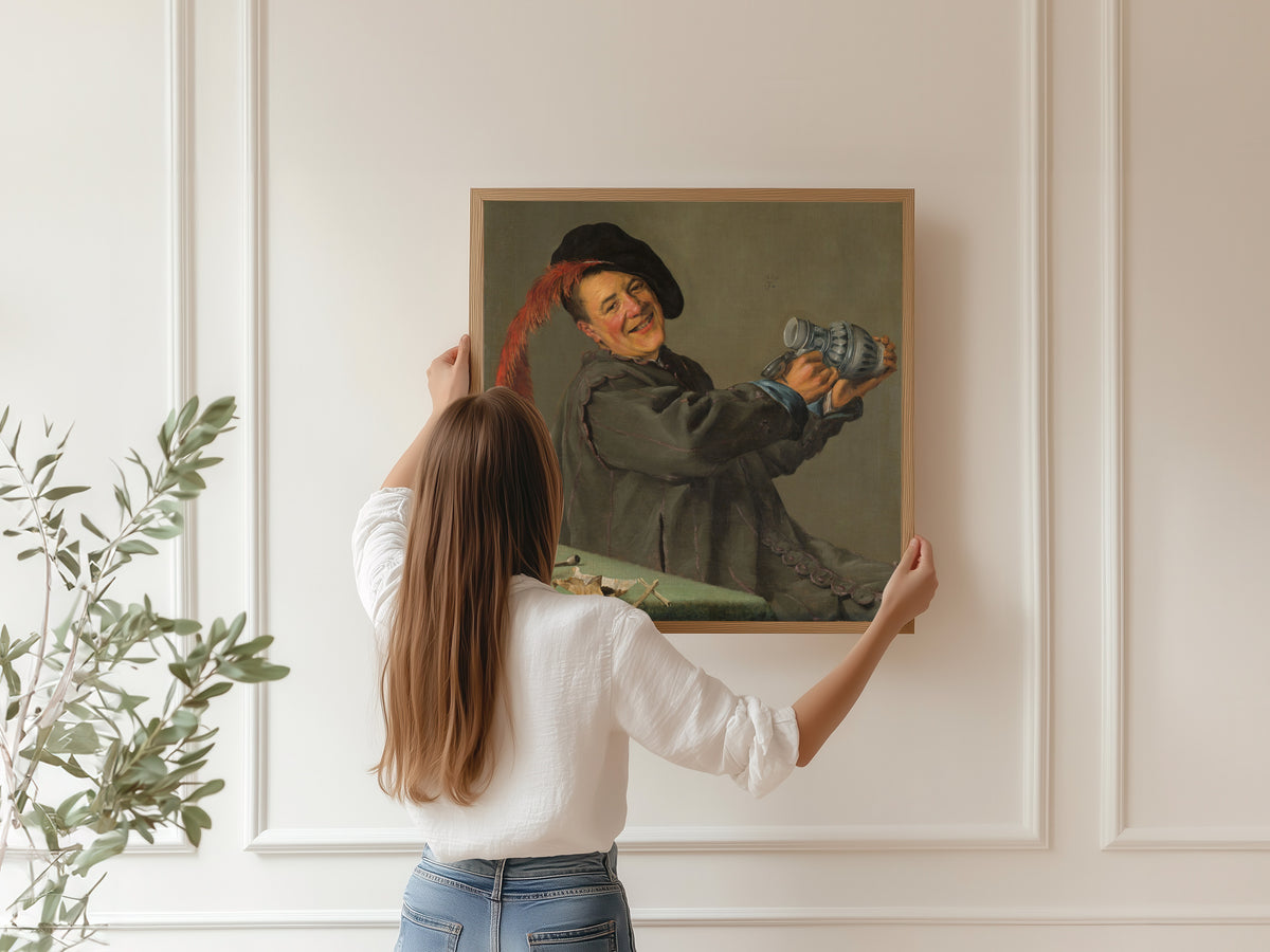Framed art print of The Merry Drinker by Judith Leyster, hung on a panelled wall