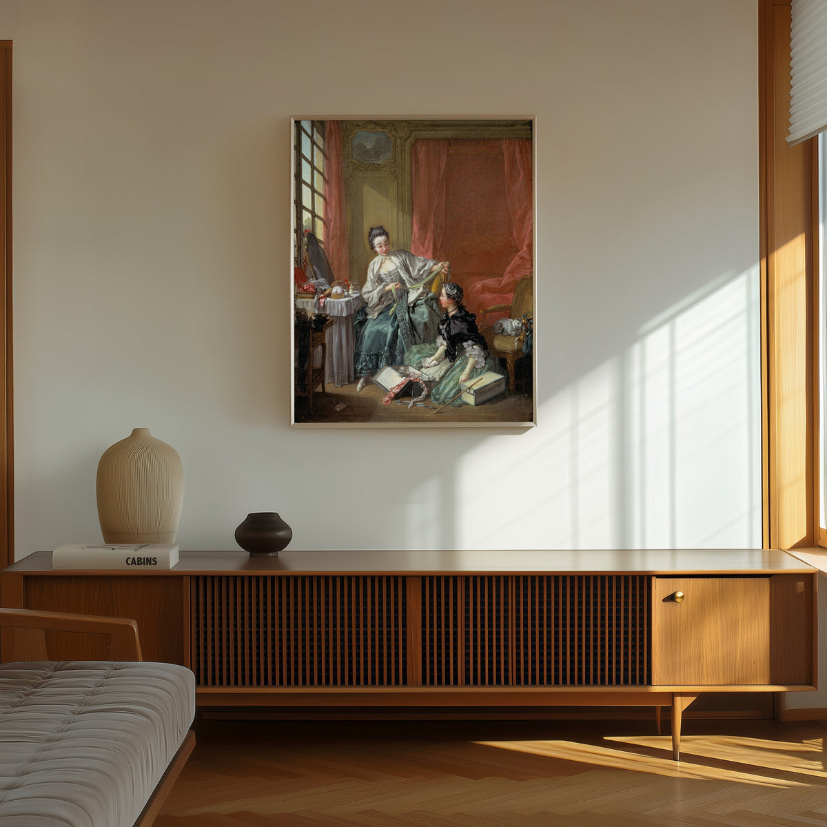 Framed art print of The Milliner by François Boucher, in a thin light frame on a sunlit wall above a wooden sideboard