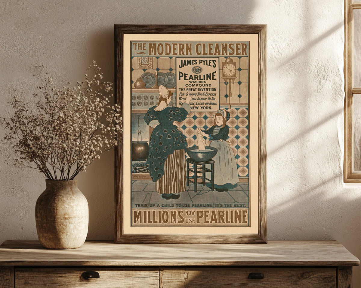 Framed art print of The Modern Cleanser, Millions Now Use Pearline by Louis Rhead, in a dark wood frame leaning on a rustic console beside dried flowers