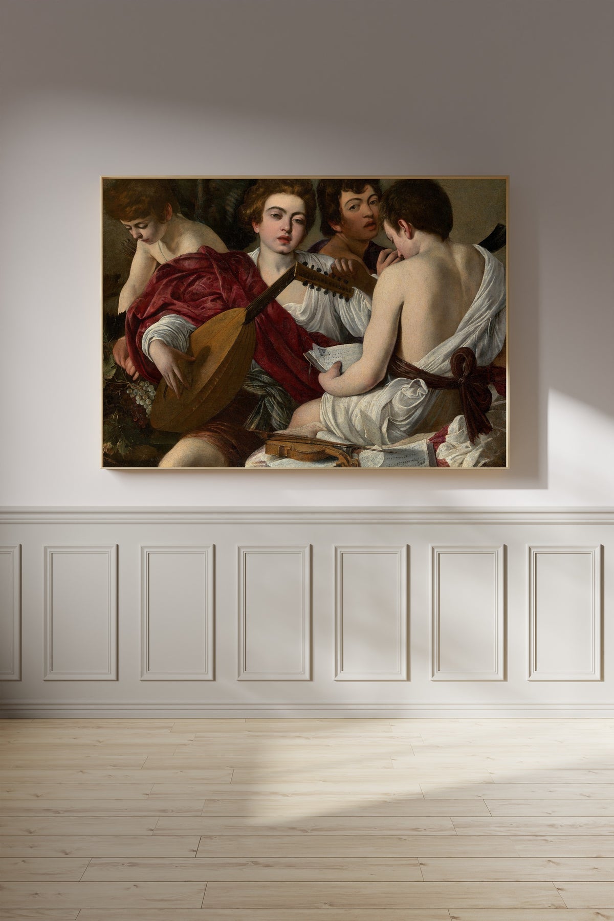 Framed art print of The Musicians by Caravaggio, on a panelled wall in afternoon light