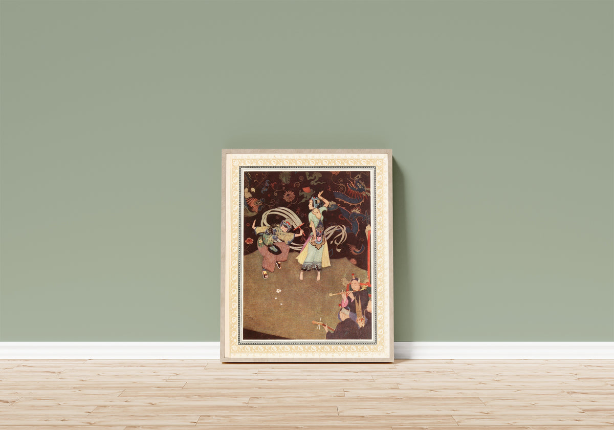 Framed art print of The Nuptial Dance of Aladdin and the Lady… by Edmund Dulac, in a light wood frame leaning on a sage green wall above a wooden floor
