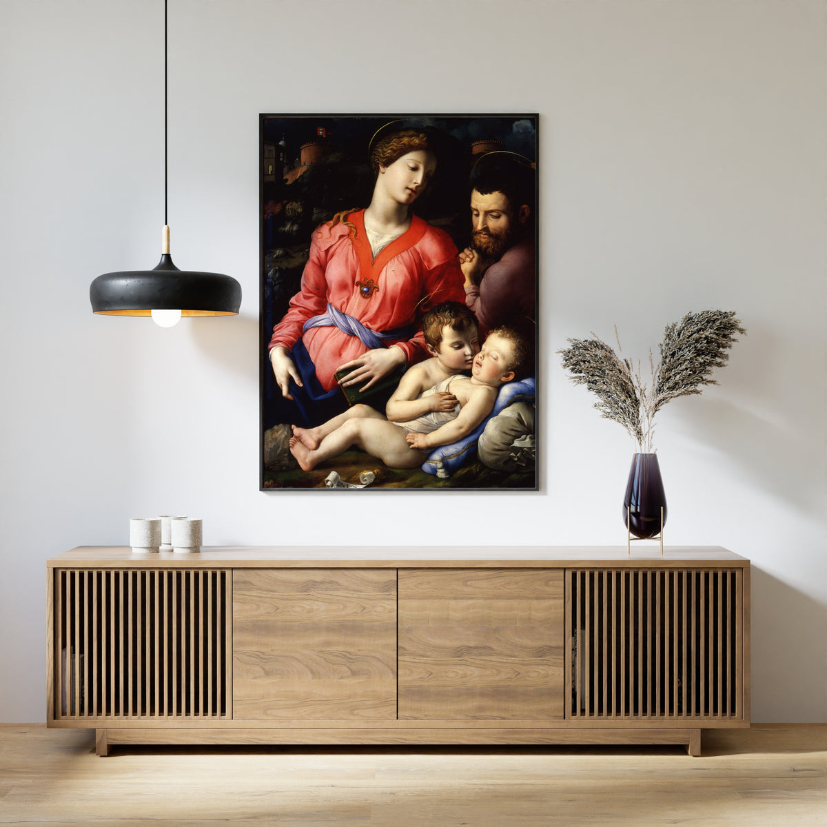 Framed art print of The Panciatichi Holy Family by Bronzino, above a slatted wood sideboard