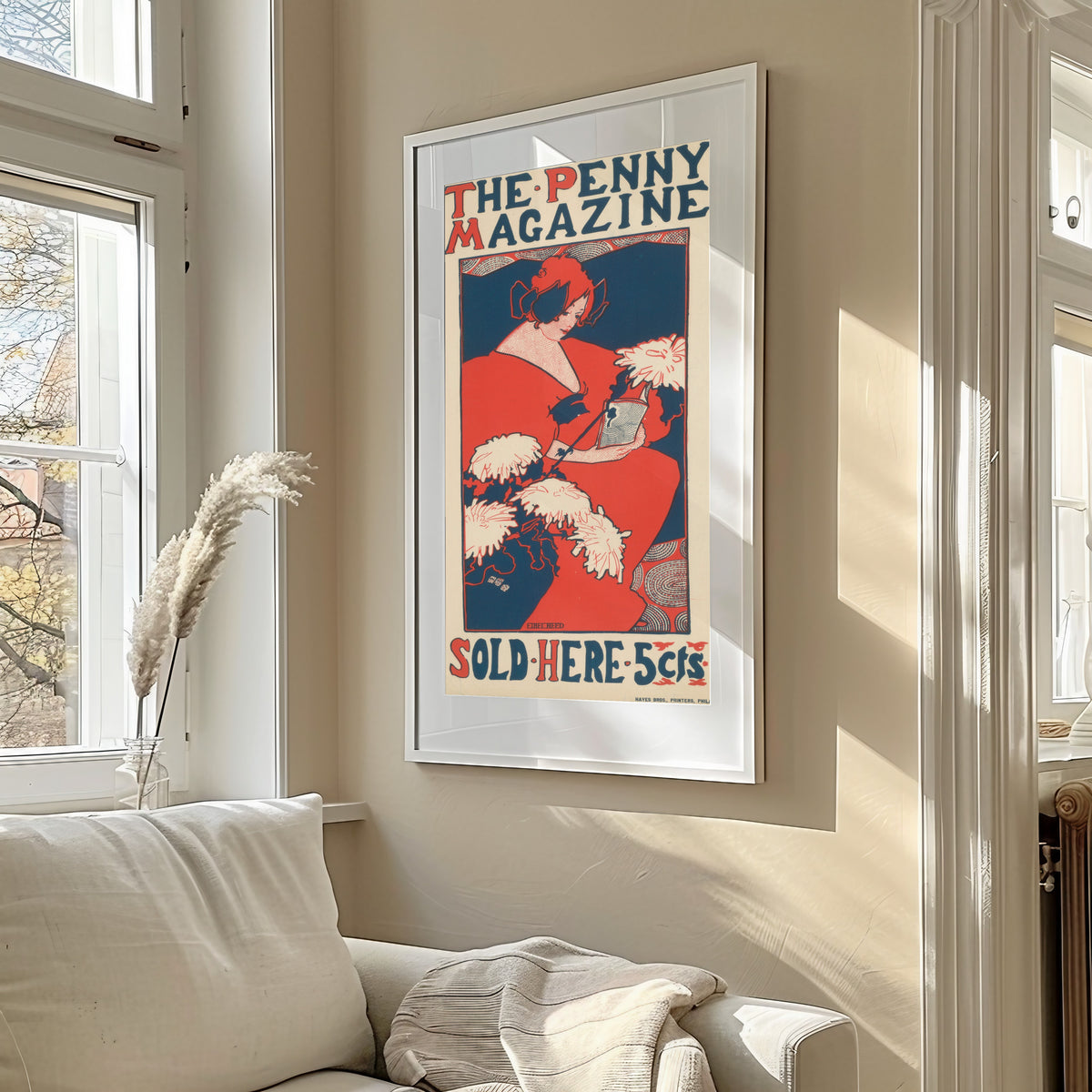 Framed art print of The Penny Magazine by Ethel Reed, in a sunlit living room above a sofa