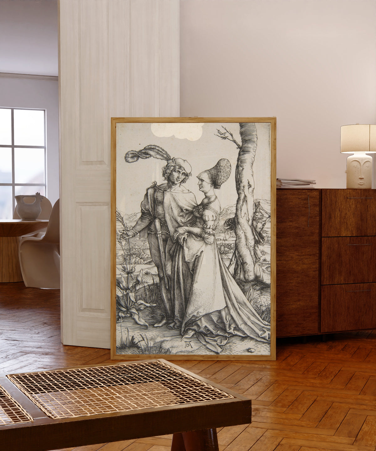 Framed art print of The Promenade by Albrecht Dürer, in a light wood frame leaning in a warm room with a parquet floor
