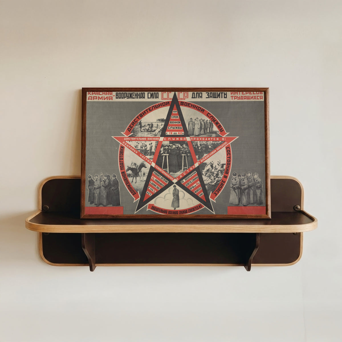 Framed art print of The Red Army: the armed force of the USSR for the defence of the interests of the working…, in a dark wood frame resting on a wall shelf