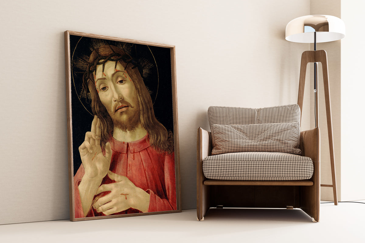 Framed art print of The Resurrected Christ by Sandro Botticelli, leaning against a wall beside an armchair and a floor lamp