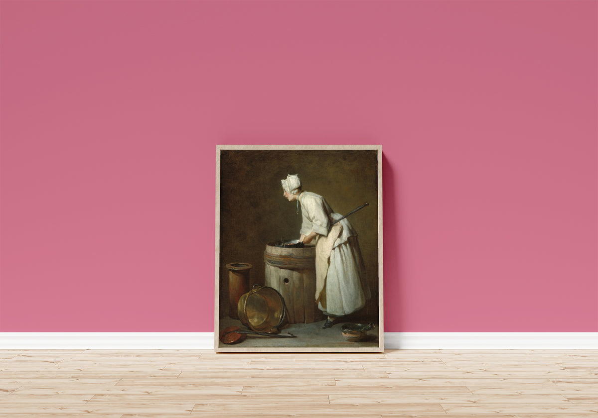 Framed art print of The Scullery Maid by Jean-Siméon Chardin, in a light wood frame leaning on a pink wall above a wooden floor