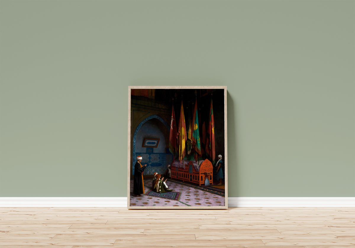 Framed art print of The Sentinel at the Sultan's Tomb by Jean-Léon Gérôme, in a light wood frame leaning on a sage green wall above a wooden floor
