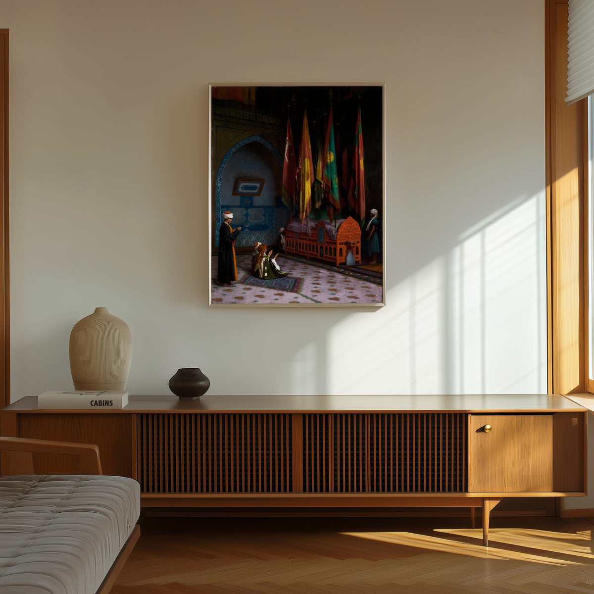 Framed art print of The Sentinel at the Sultan's Tomb by Jean-Léon Gérôme, in a thin light frame on a sunlit wall above a wooden sideboard