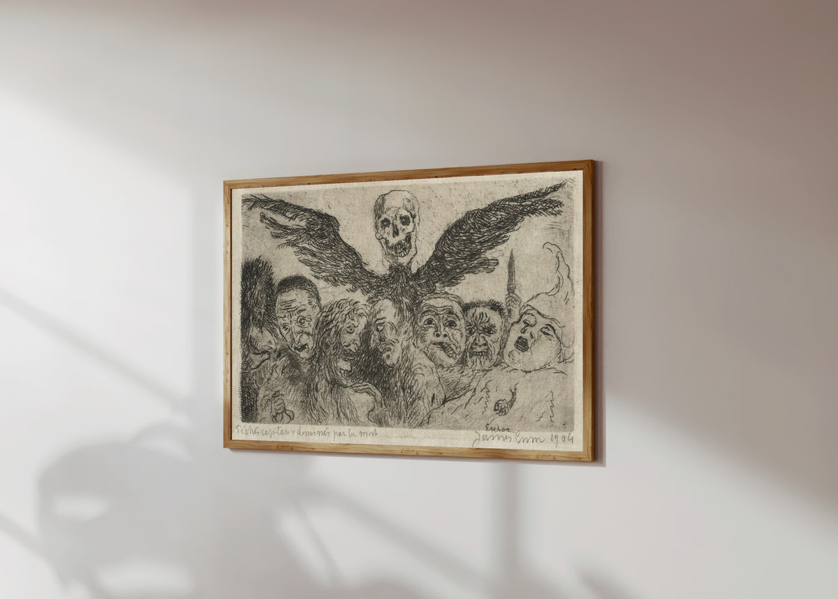 Framed art print of The Seven Deadly Sins Dominated by Death by James Ensor, in a light wood frame on a sunlit white wall, seen at a slight angle