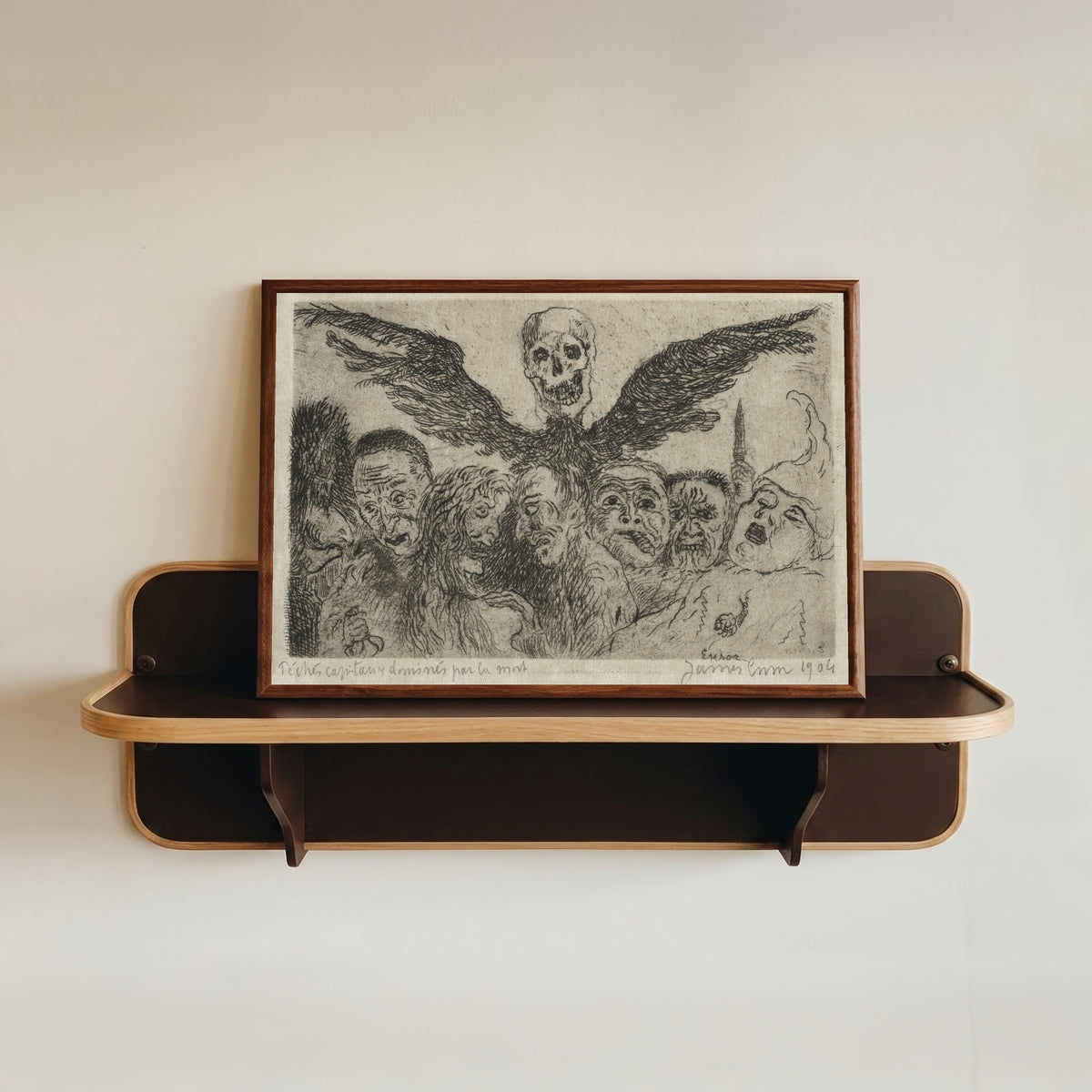 Framed art print of The Seven Deadly Sins Dominated by Death by James Ensor, in a dark wood frame resting on a wall shelf