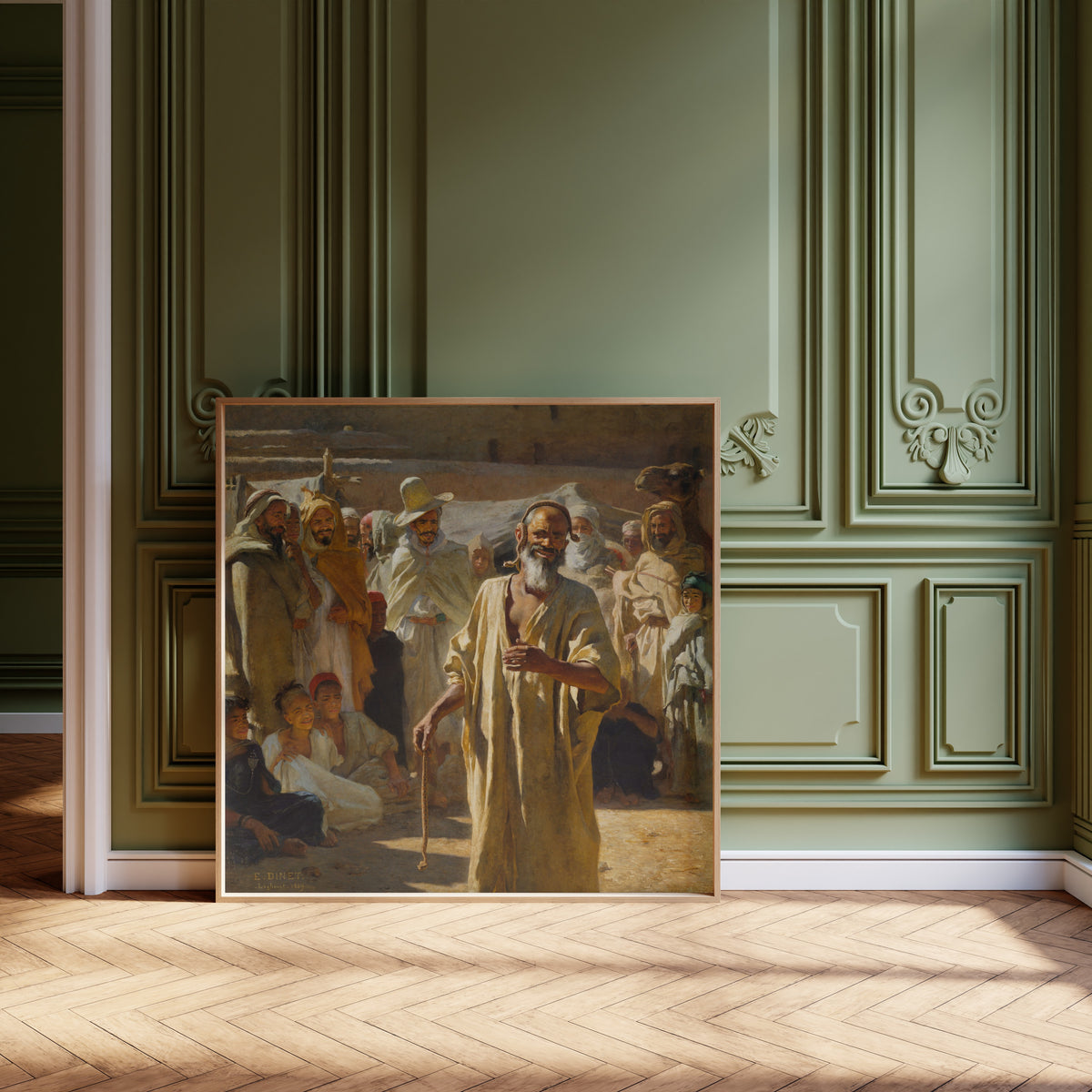 Framed art print of The Snake Charmer by Étienne Dinet, leaning against olive-green panelling on a herringbone floor