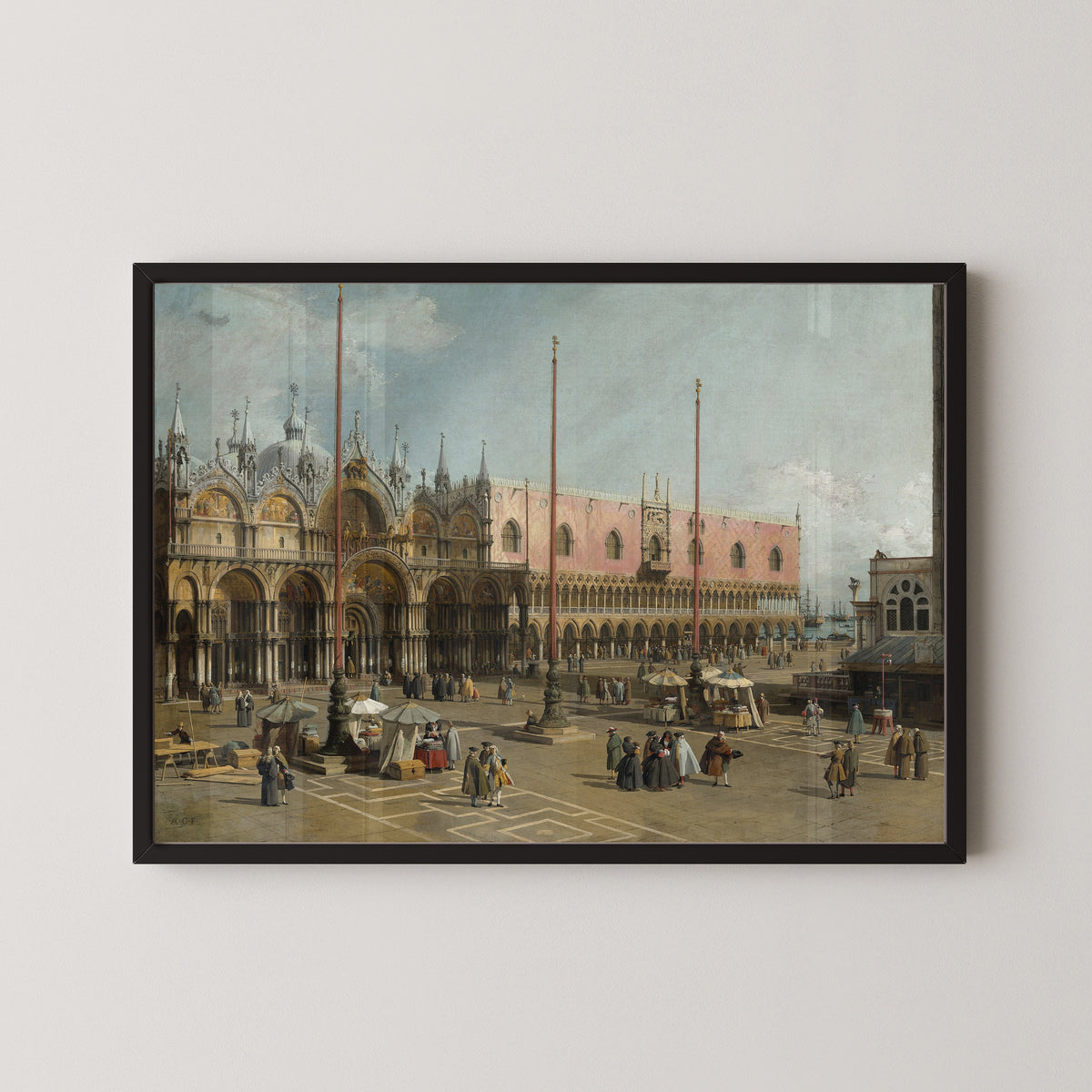 Framed art print of The Square of Saint Mark’s, Venice by Canaletto, in a black frame on a pale wall
