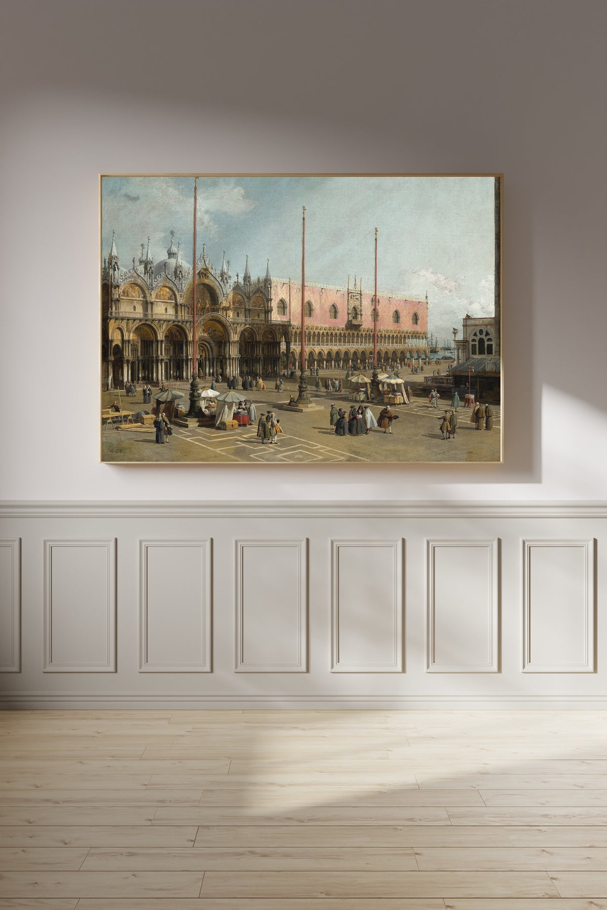 Framed art print of The Square of Saint Mark’s, Venice by Canaletto, on a panelled wall in afternoon light