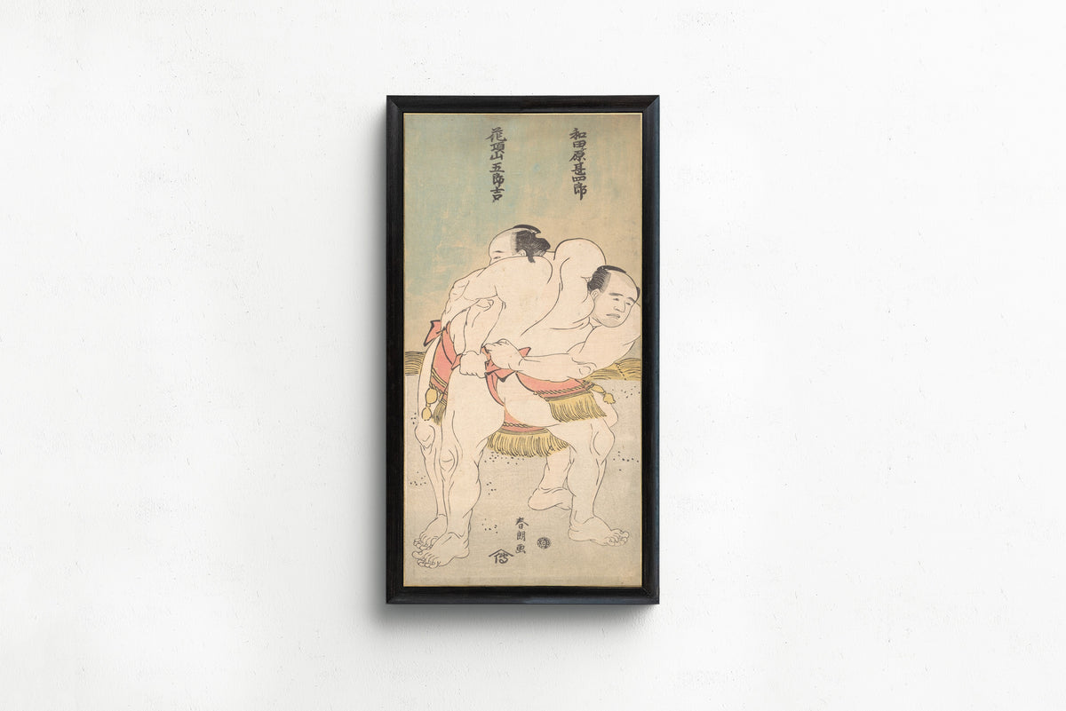 Framed art print of The Sumo Wrestlers Wadagahara Jinshirō and Kachōzan Gorokichi by Katsushika Hokusai, in a slim black frame on a plain white wall