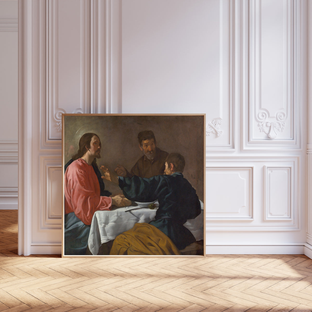Framed art print of The Supper at Emmaus by Diego Velázquez, leaning against pale pink panelling on a herringbone floor