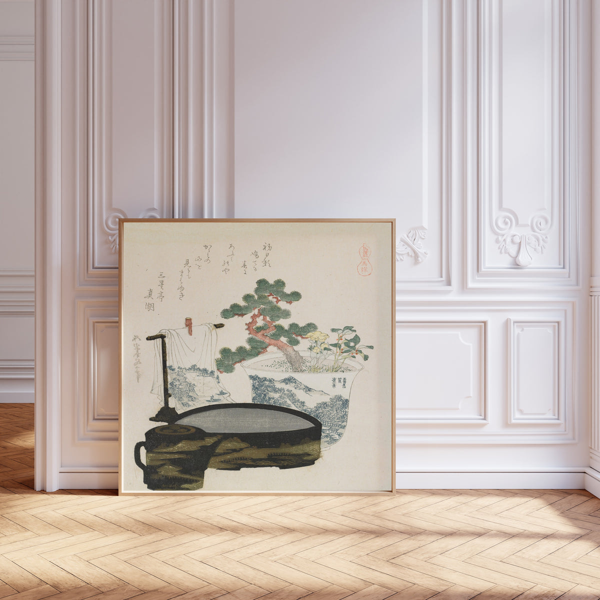 Framed art print of The Talisman by Katsushika Hokusai, leaning against pale pink panelling on a herringbone floor