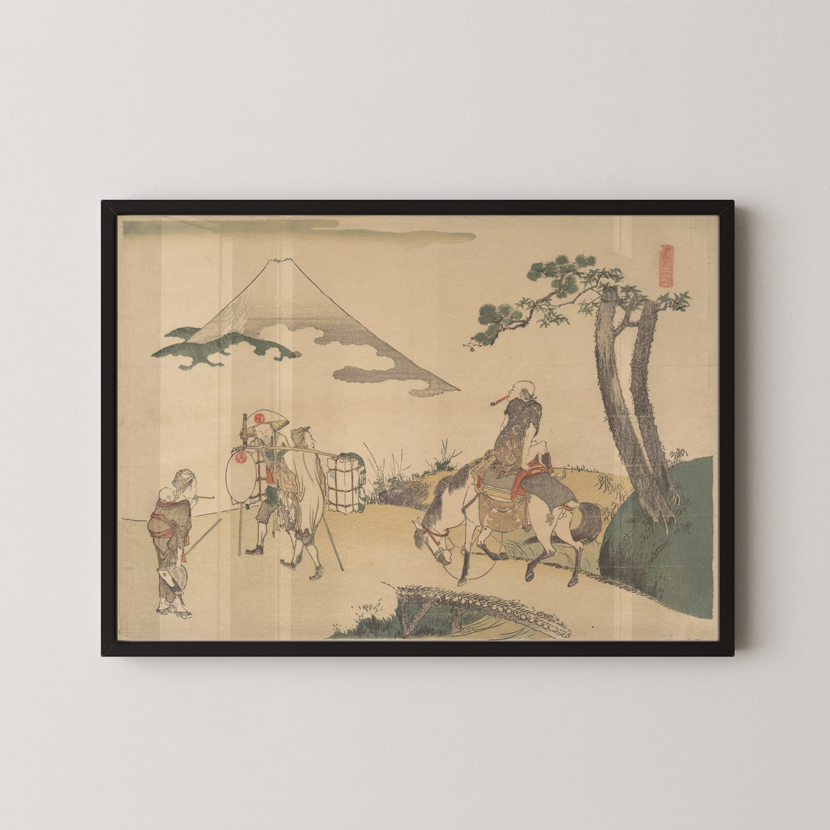 Framed art print of The Top of Mount Fuji by Katsushika Hokusai, in a black frame on a pale wall