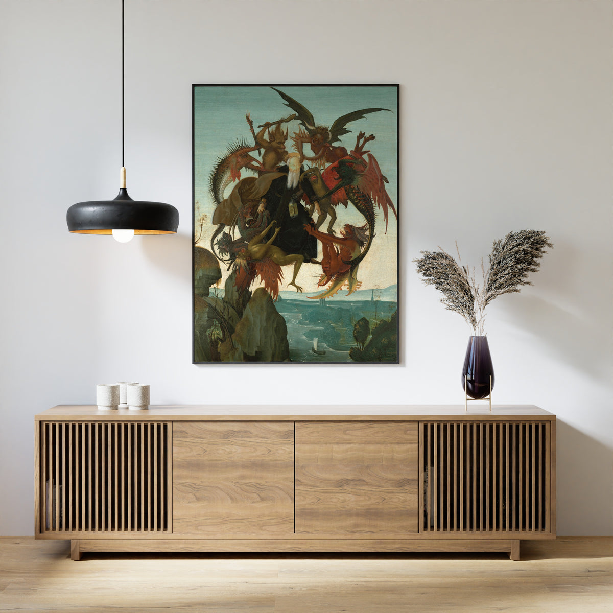 Framed art print of The Torment of Saint Anthony by Michelangelo, above a slatted wood sideboard