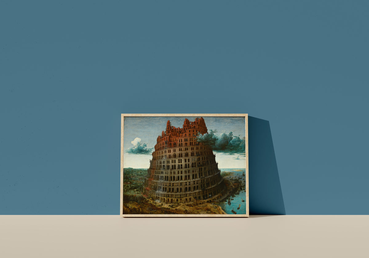 Framed art print of The Tower of Babel (Rotterdam) by Pieter Bruegel the Elder, in a light wood frame leaning on a blue wall