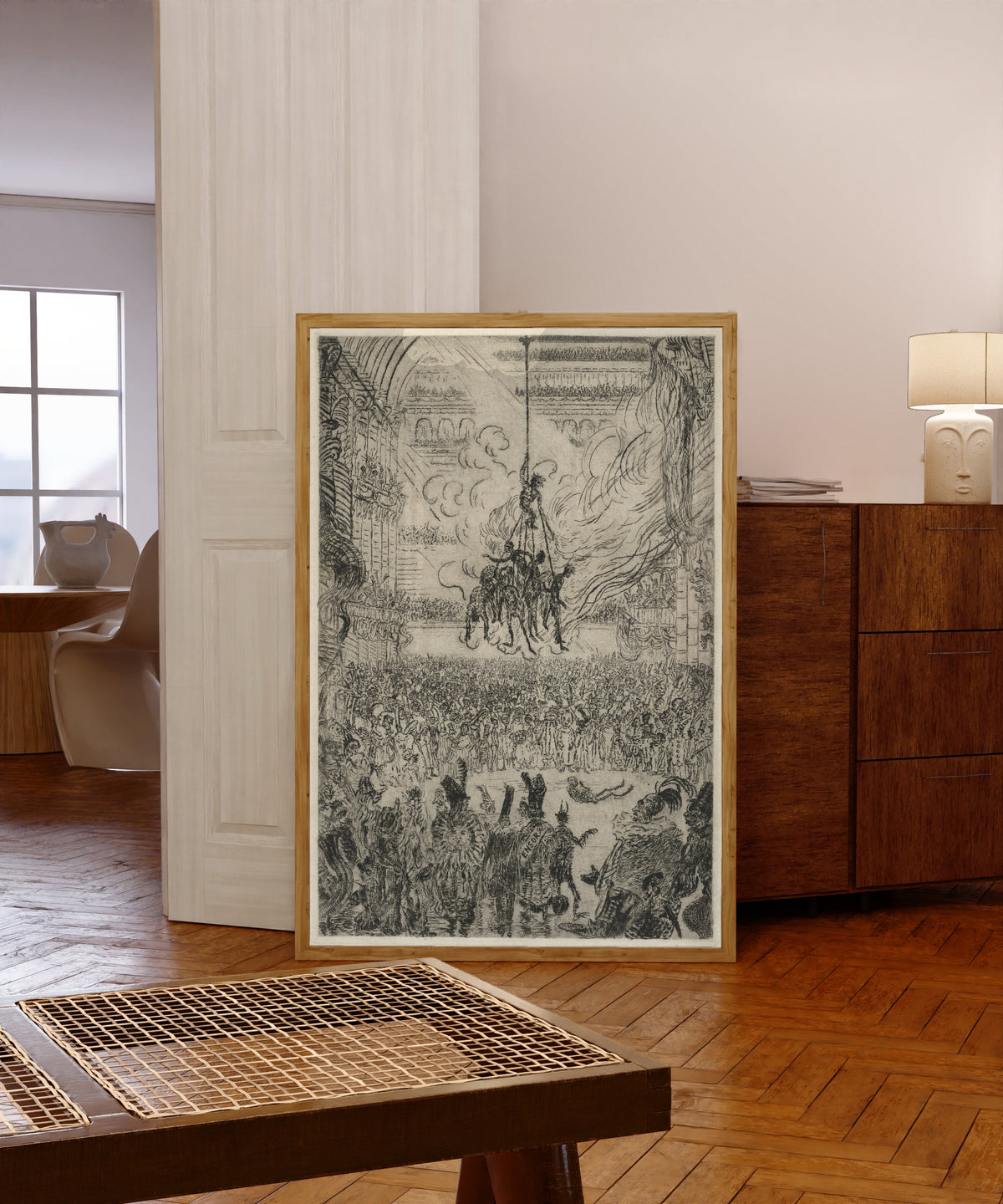 Framed art print of The Vengeance of Hop-Frog by James Ensor, in a light wood frame leaning in a warm room with a parquet floor