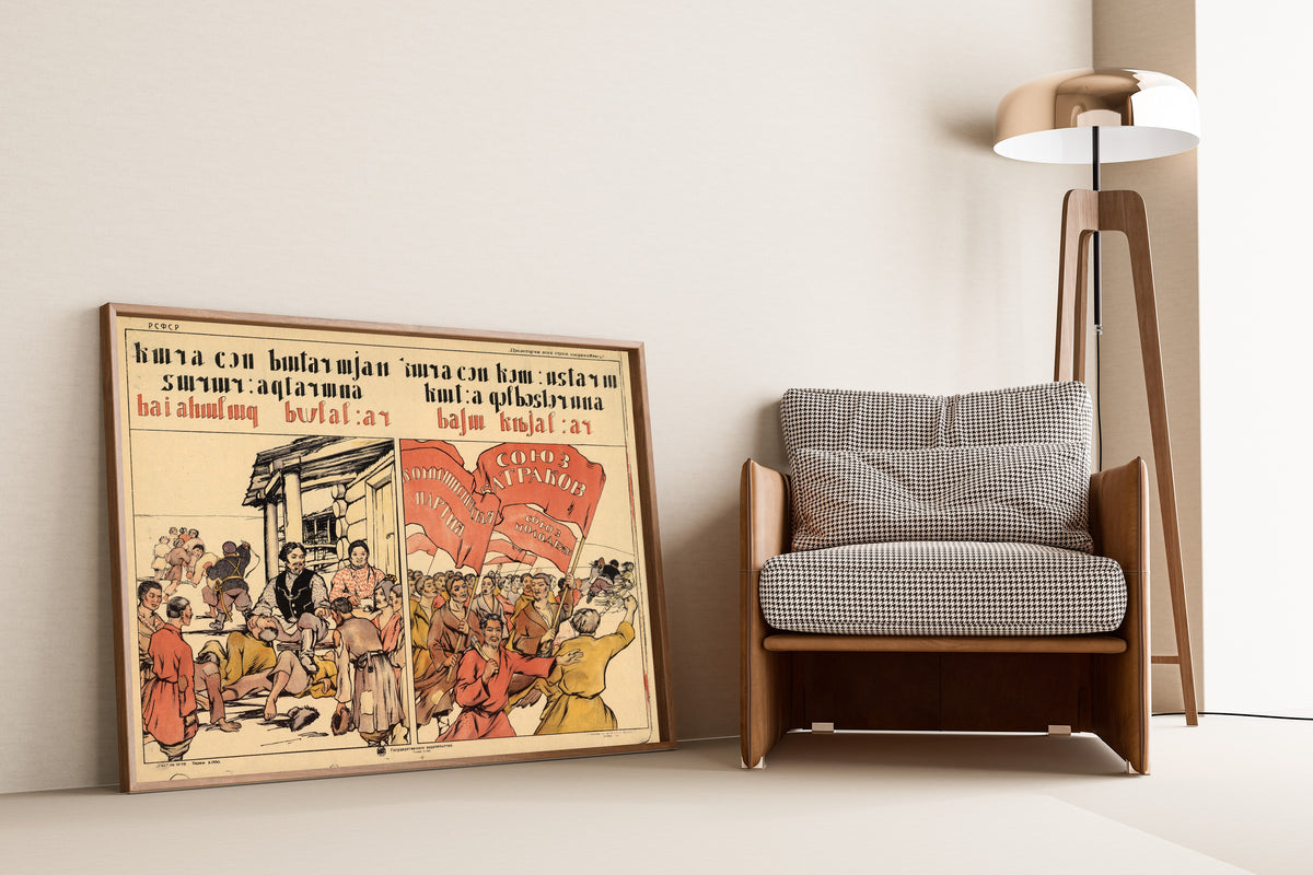 Framed art print of The Village Before, the Village Now, leaning against a wall beside an armchair and a floor lamp
