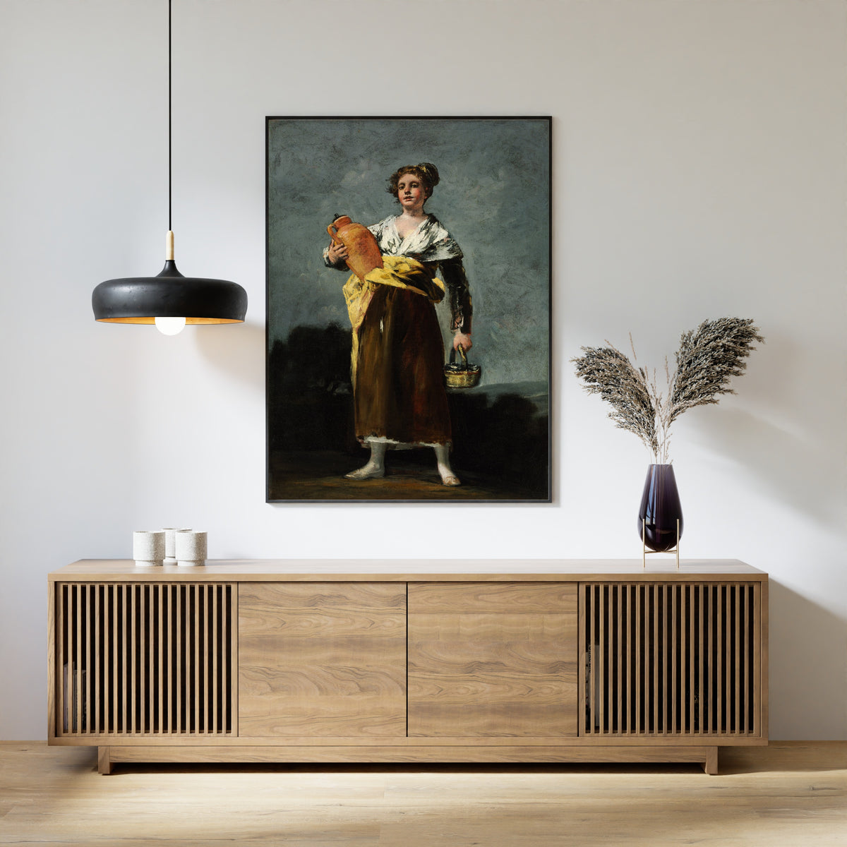 Framed art print of The Water Carrier (La Aguadora) by Francisco de Goya, above a slatted wood sideboard