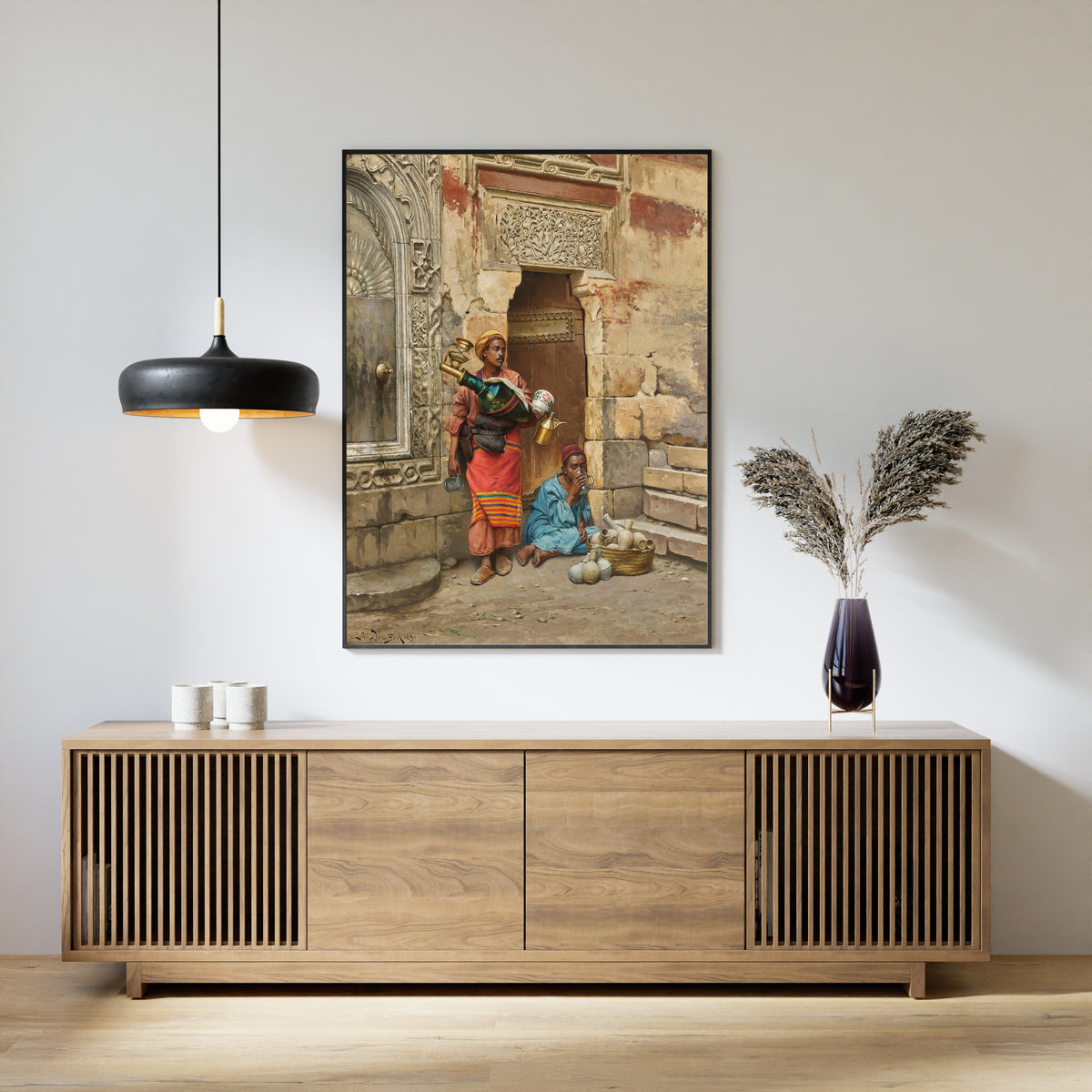 Framed art print of The Water Seller by Ludwig Deutsch, above a slatted wood sideboard