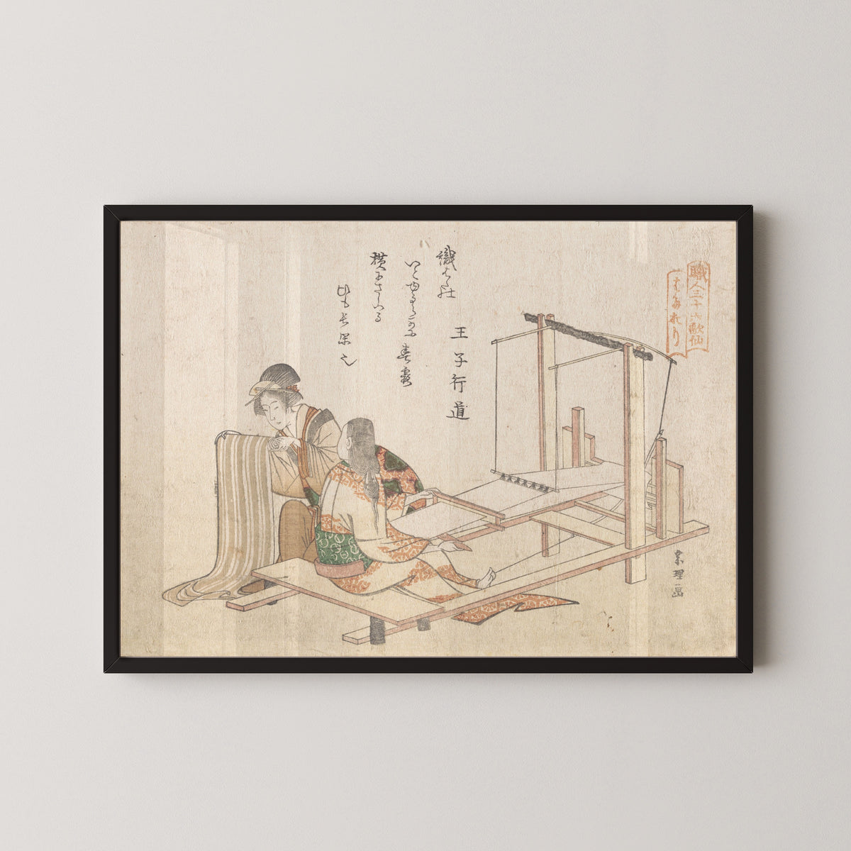 Framed art print of The Weaving Factory by Katsushika Hokusai, in a black frame on a pale wall
