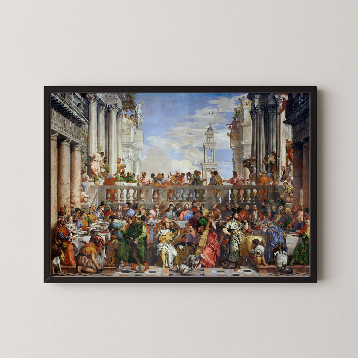 Framed art print of The Wedding at Cana by Paolo Veronese, in a black frame on a pale wall