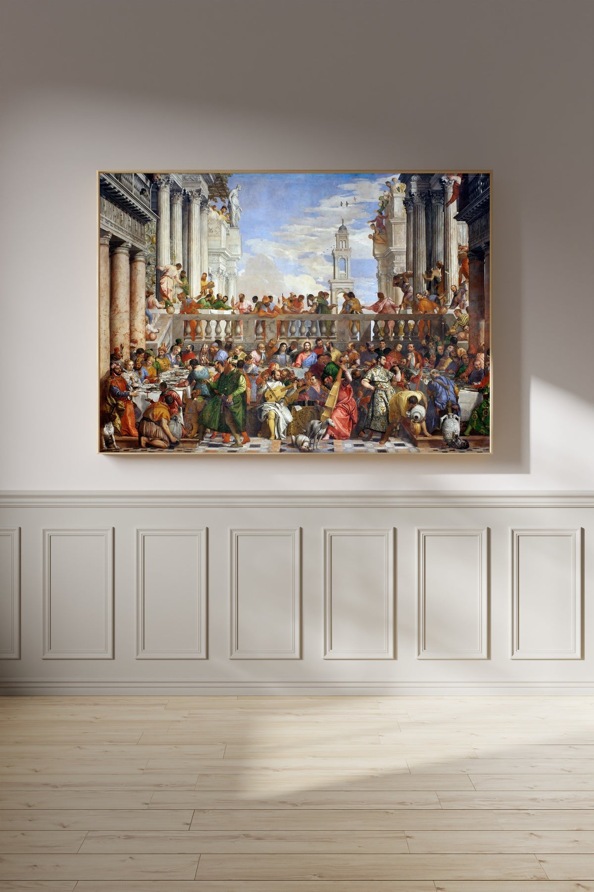 Framed art print of The Wedding at Cana by Paolo Veronese, on a panelled wall in afternoon light
