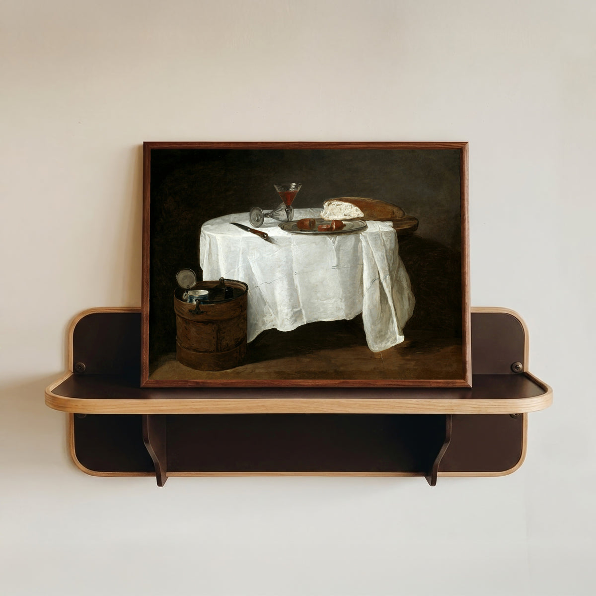 Framed art print of The White Tablecloth by Jean-Siméon Chardin, in a dark wood frame resting on a wall shelf