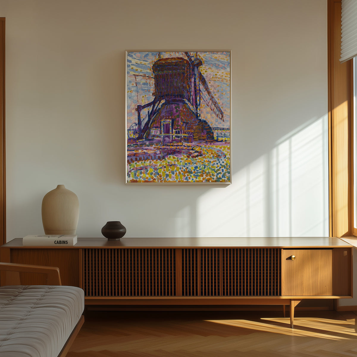 Framed art print of The Winkel Mill by Piet Mondrian, in a thin light frame on a sunlit wall above a wooden sideboard