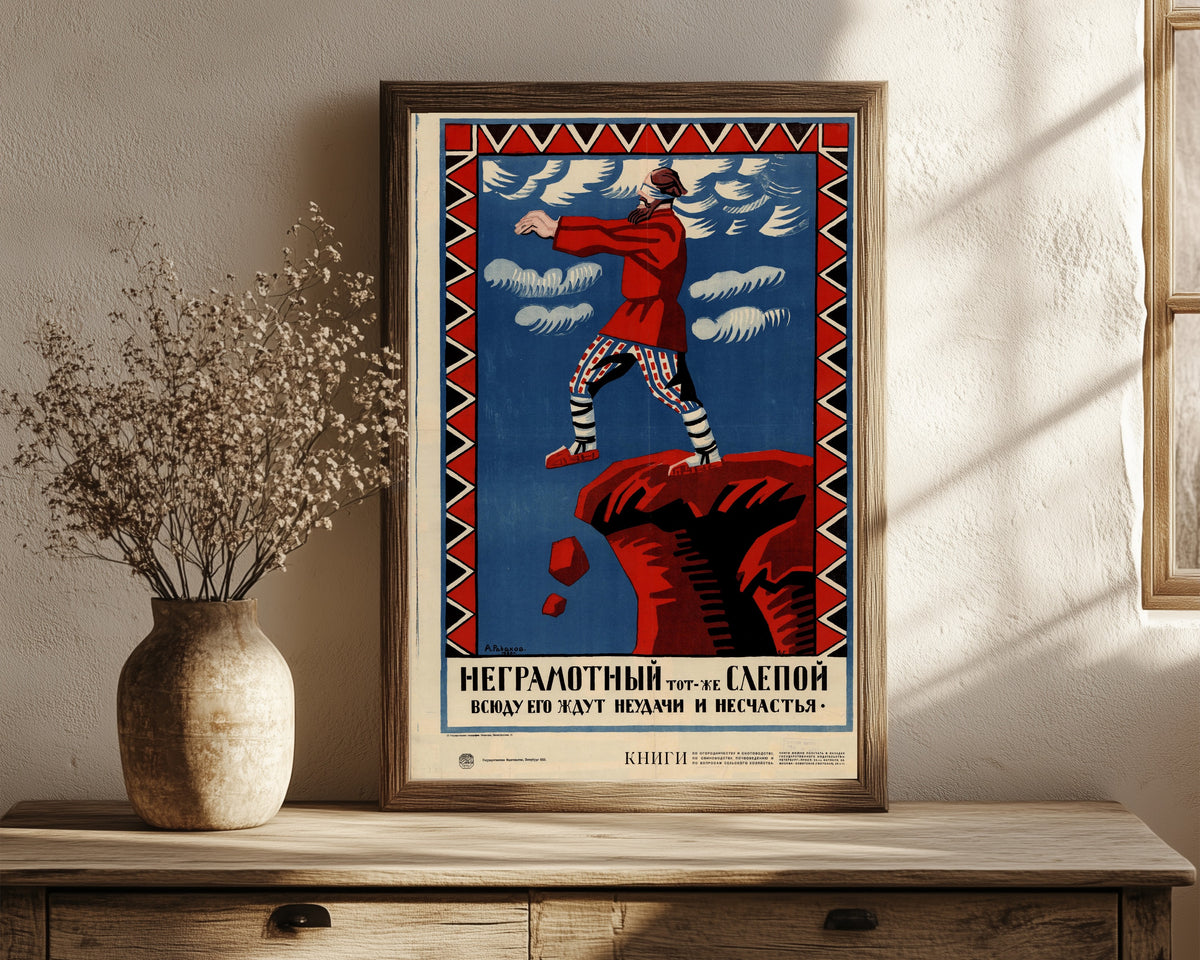 Framed art print of The illiterate is as good as blind: failure and… by Aleksei Radakov, in a dark wood frame leaning on a rustic console beside dried flowers