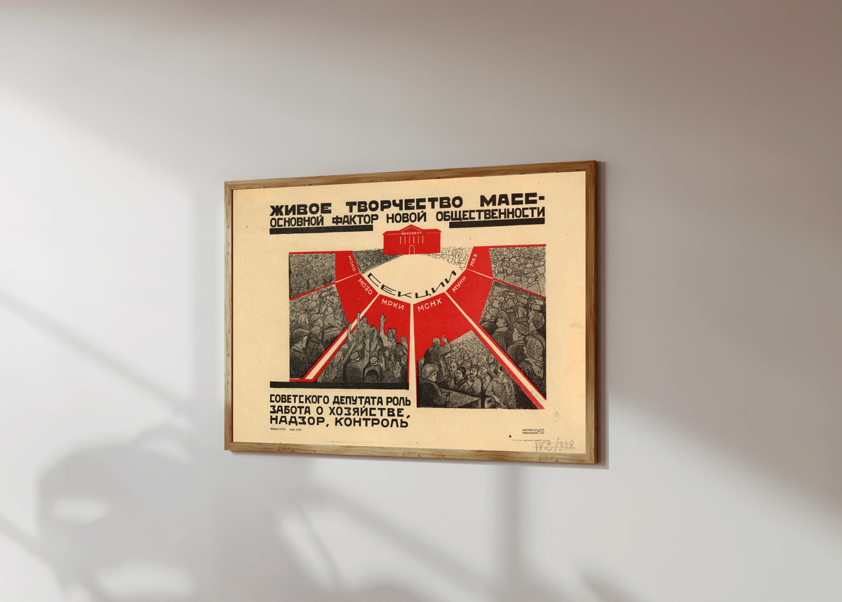 Framed art print of The living creativity of the masses is the main factor of the new…, in a light wood frame on a sunlit white wall, seen at a slight angle