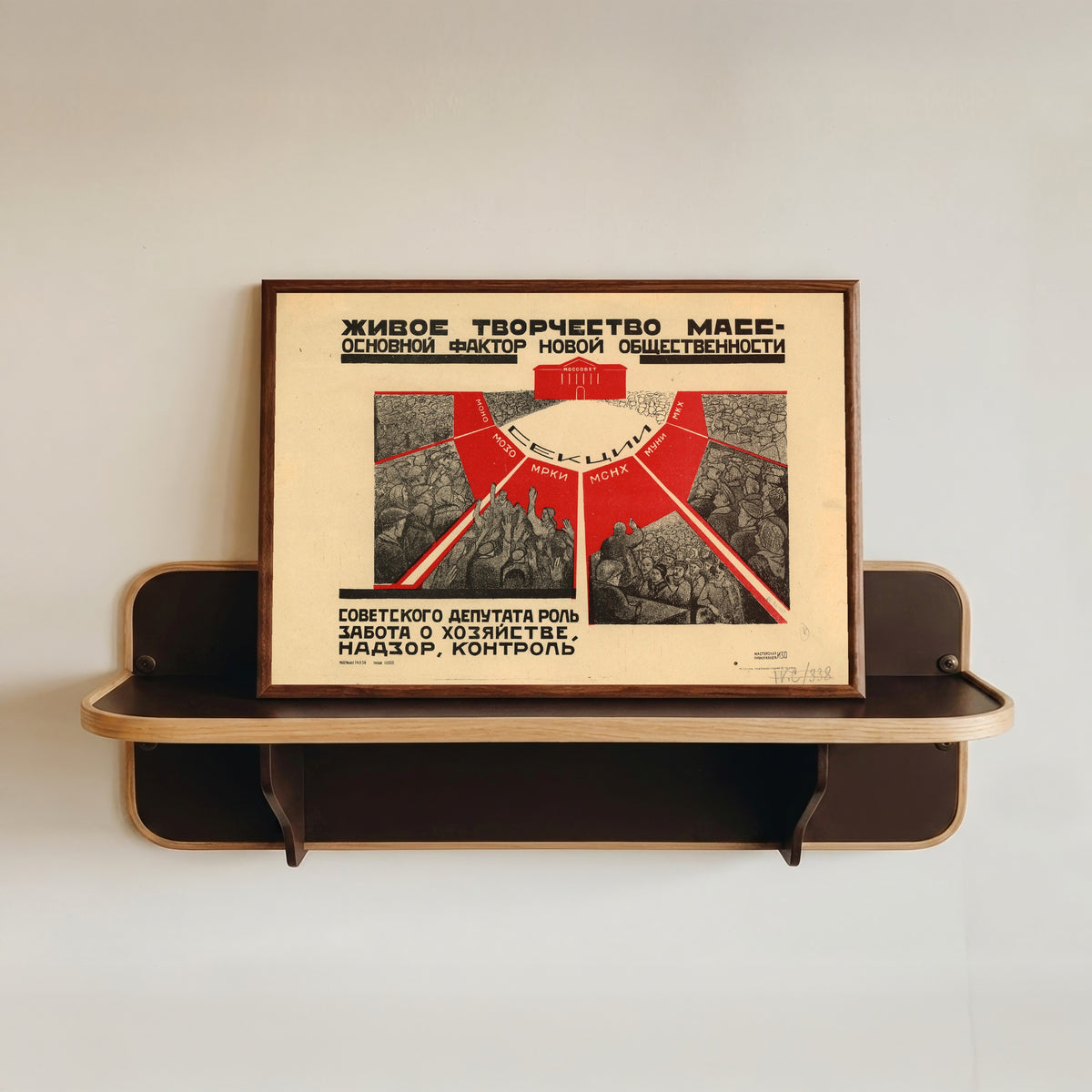 Framed art print of The living creativity of the masses is the main factor of the new public life, in a dark wood frame resting on a wall shelf