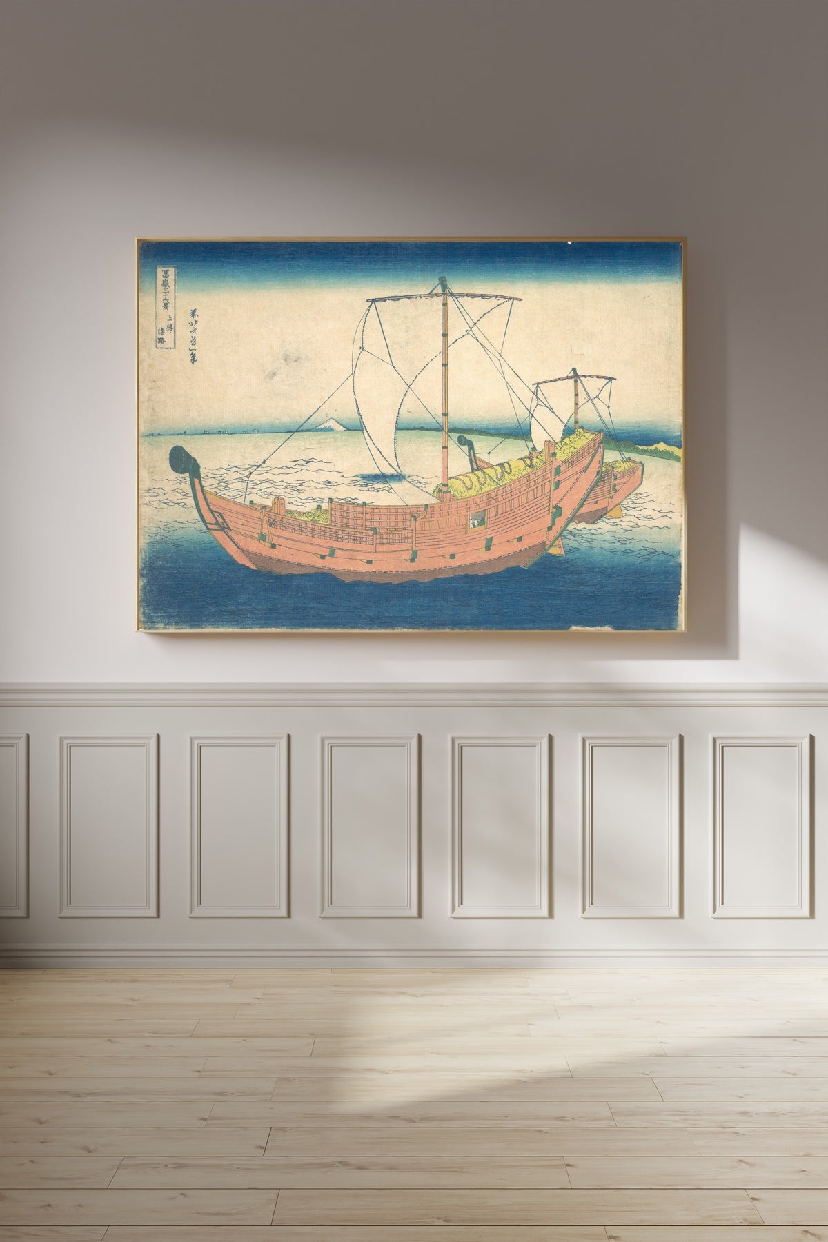 Framed art print of Thirty-six Views of Mount Fuji: At Sea off Kazusa by Katsushika Hokusai, on a panelled wall in afternoon light