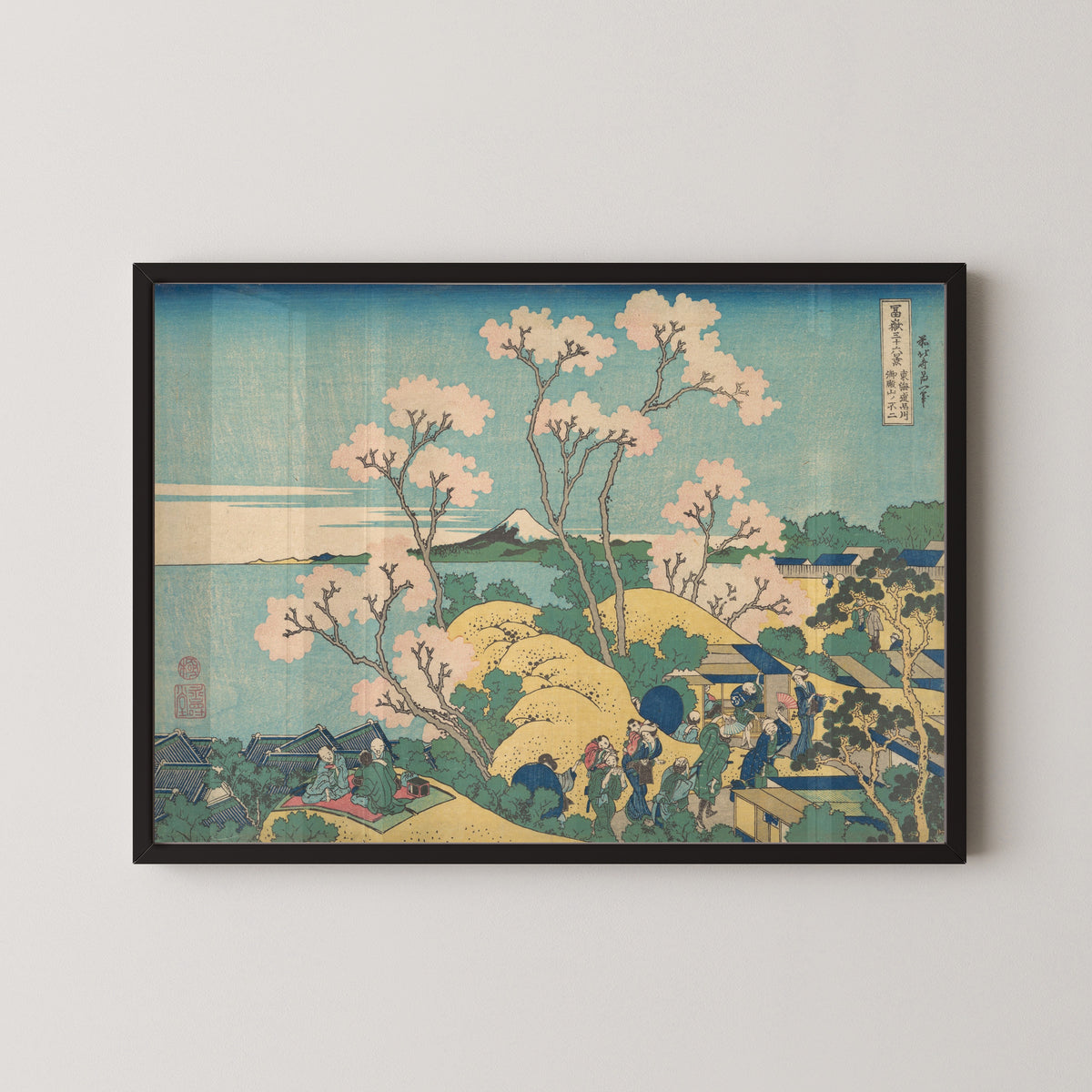 Framed art print of Thirty-six Views of Mount Fuji: Fuji from Gotenyama on the Tōkaidō at Shinagawa by Katsushika Hokusai, in a black frame on a pale wall
